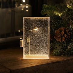 Kit DIY de lámpara de nieve con farola LED sobre una mesa decorada